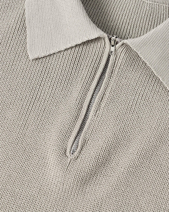 Close-up of a gray sweater with a collar and zipper, featuring the Parjan brand label.
